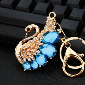 Macro view of crystal-encrusted swan keychain with light blue gemstones and gold lobster clasp
