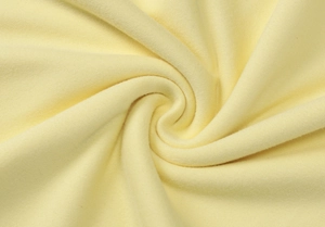 Macro shot of the soft yellow knitted fabric texture and ribbed pattern of the dress