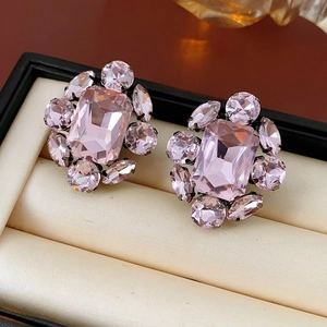 Vue détaillée de boucles d'oreilles vintage en cristal rose dans un écrin en velours beige