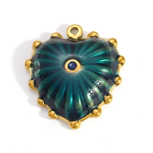 Macro shot of gold heart pendant with green enamel and blue gemstone inlay