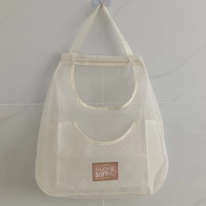 Hanging white mesh storage bag for ginger and garlic with a brown decorative label