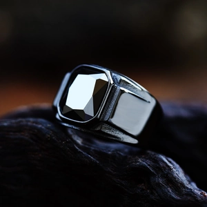 Macro detail of men's black stainless steel signet ring with a large faceted gemstone