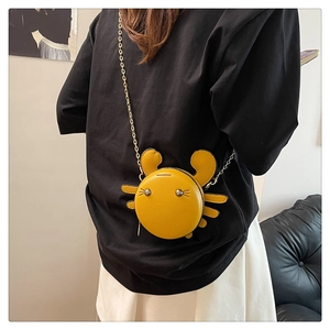 Compact yellow crab-shaped PU leather crossbody bag with metal chain shown on model