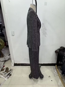 Dettaglio di tailleur in tweed grigio che mostra la trama del tessuto e la sagoma