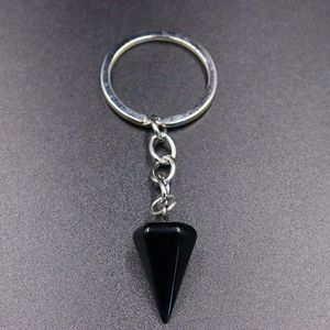 Close-up of hexagonal black crystal obsidian pendulum pendant with silver keychain