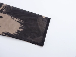 Detail van zwarte mesh mouw met beige abstracte print en afwerking van de manchetten
