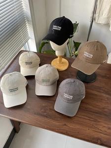 Detail showing variety of six classic colors of cotton baseball caps with embroidery