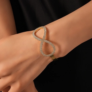 Dettaglio del bracciale a nodo infinito dorato con intarsio in zirconi scintillanti