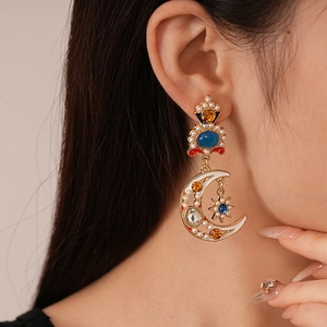 Close-up of vintage celestial pearl and rhinestone moon earrings on ear for a luxury look