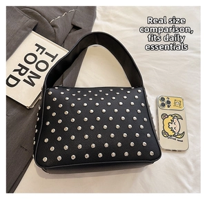 Detailed size comparison of black studded tote bag with a smartphone and books