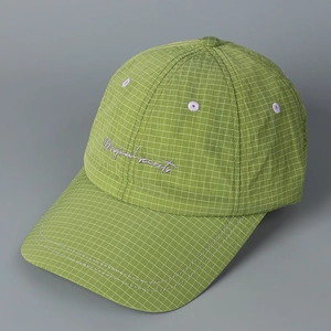 Close-up of green checkered baseball cap with purple Magical secrets embroidery