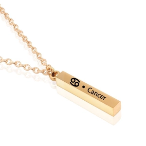 Macro detail of golden Cancer zodiac pillar pendant with engraving on cross chain