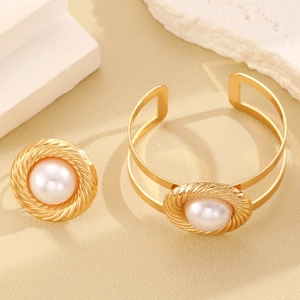 Detailed view of gold leaf-style bangle and ring set with white round pearls