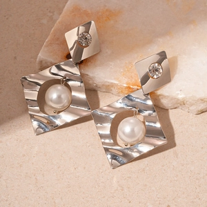 Silver geometric earrings featuring pearls and crystals on a natural stone base