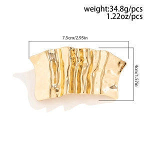 Detailed view of golden irregular pleated metal hair clip with size 7.5cm by 4cm dimensions
