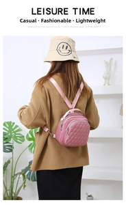 Detail of pink quilted waterproof nylon mini backpack worn by model in a modern interior
