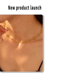 Detail shot of a gold-plated flower-shaped bead necklace worn on the collarbone