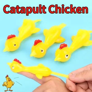Elastic yellow turkey slingshot toy being stretched by fingers for launching action