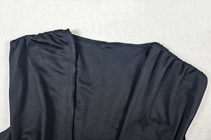 Detailed close-up of ruched shoulder and sleek black fabric on sleeveless V-neck dress