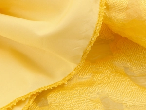 Detailed macro view of yellow jacquard and smooth fabric with professional stitching