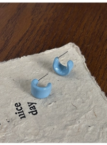 Detailed macro view of sky blue C-shape resin earring featuring S925 sterling silver post