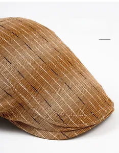 Close-up of brown striped flat cap fabric showing detailed cotton linen texture and wide brim