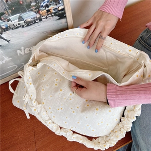 Detail of canvas bag interior showing zipper pocket and daisy pattern shoulder strap