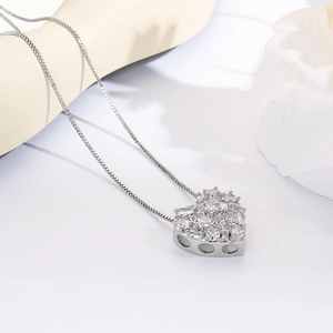 Detailed close-up of a silver-tone heart pendant necklace with shimmering cubic zirconia