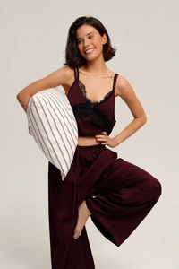 Detail of burgundy satin pajama set with black lace trim and wide-leg trousers