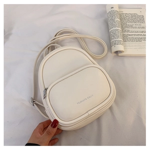 Close-up of white mini fashion backpack with soft texture and embossed detail