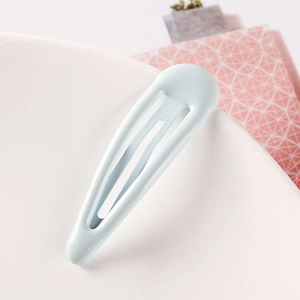 Macro view of a mint blue teardrop BB hair clip with a smooth glossy lacquer finish