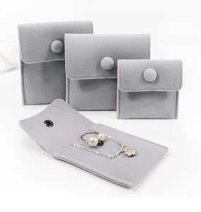 Detailed view of grey velvet jewelry pouches in three sizes with snap button closure