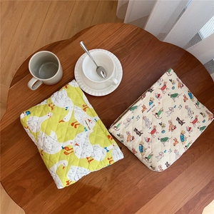Quilted cotton tablet cases with cute animal prints on a rustic wooden table setup