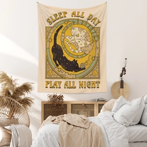 Detail of bohemian tapestry featuring black and white cats with celestial moon and sun motifs