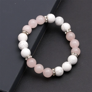 Dettaglio del bracciale di perline occhio di gatto rosa e turchese bianco con distanziatori