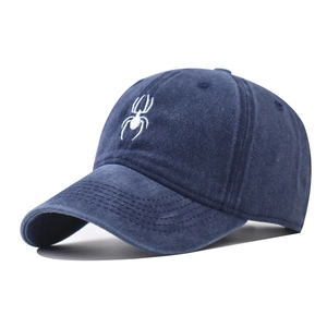 Detail of white spider embroidery on navy blue washed cotton baseball cap with curved brim