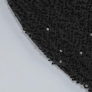 Detailed macro view of shimmering black sequins on breathable mesh fabric for evening gowns