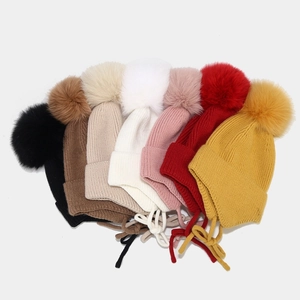 Bonnet à oreilles en tricot avec pompon en fourrure et lanières en sept coloris