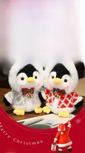 Close-up of cute Christmas penguin plush with red hooded coat and golden bell detail