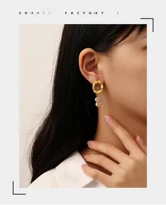 Detail of asymmetrical gold textured earrings with irregular flat lavender pearls on model