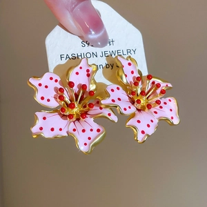 Close-up of pink enamel flower earrings with S925 silver posts and golden accents