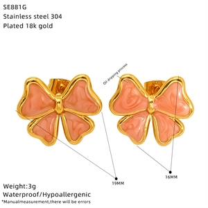 Detail view of 18k gold plated stainless steel bow earrings with pink oil drop finish