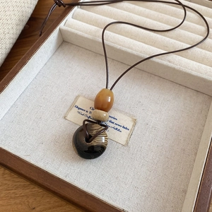 Dettaglio della collana con ciondolo a cuore in ceramica retrò in una scatola di legno