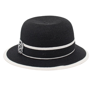 Women's black woven straw sun hat with white trim and camellia flower detail