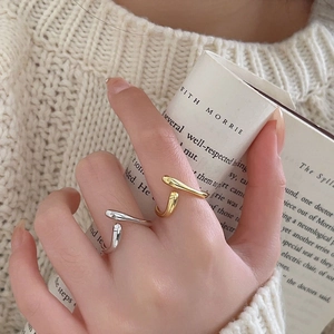 Minimalist U-shaped 925 silver ring shown worn by hand holding a vintage book