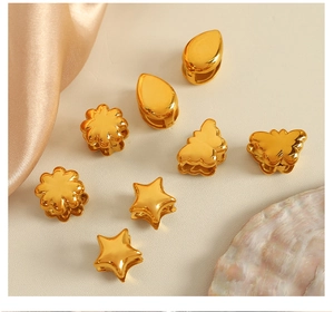 Detailed macro view of assorted golden mini hair clips in star, flower, and butterfly shapes