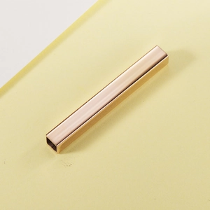 Polished golden stainless steel rectangular tube charm accessory shown at a 45-degree angle