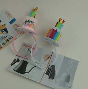 Detail view of two birthday cake headbands with colorful candles and Happy Birthday text