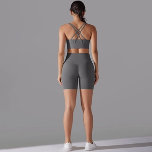 Dettaglio del set yoga grigio con reggiseno sportivo incrociato e pantaloncini a vita alta
