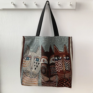 Close-up of tapestry tote bag featuring artistic cat prints and thick woven texture